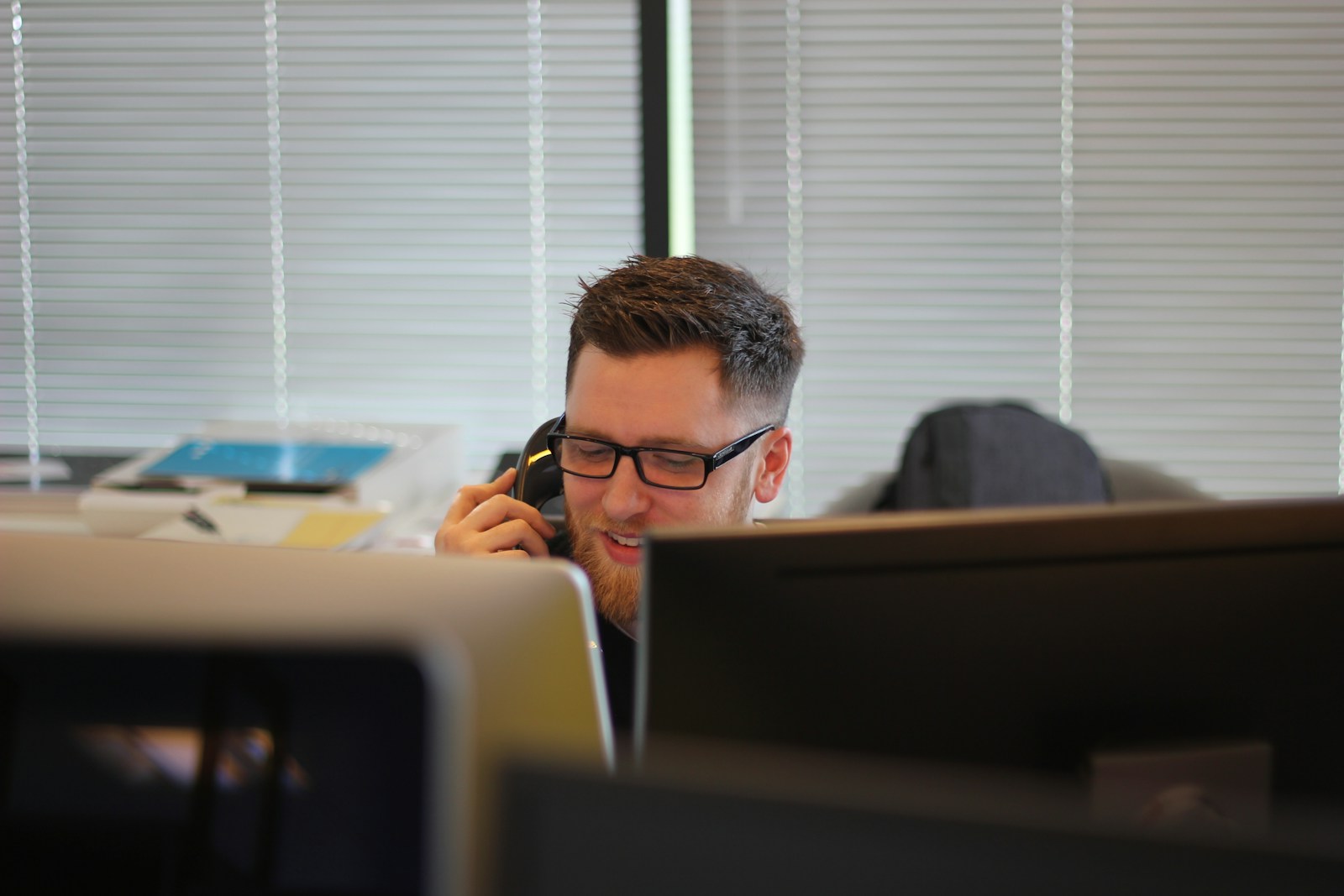 Man taking a phone call at his desk in an office